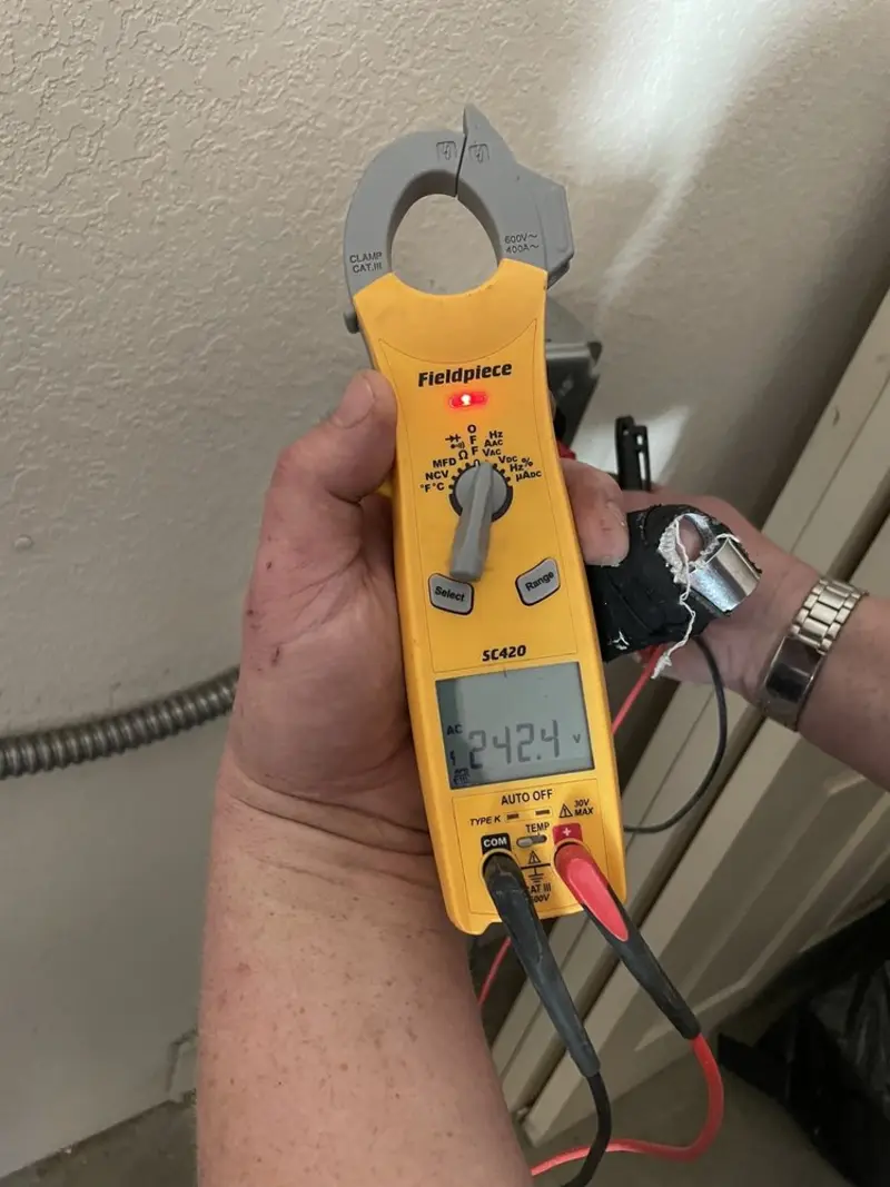 Voltage testing with clamp meter during Outlet Installation in Ives Estates